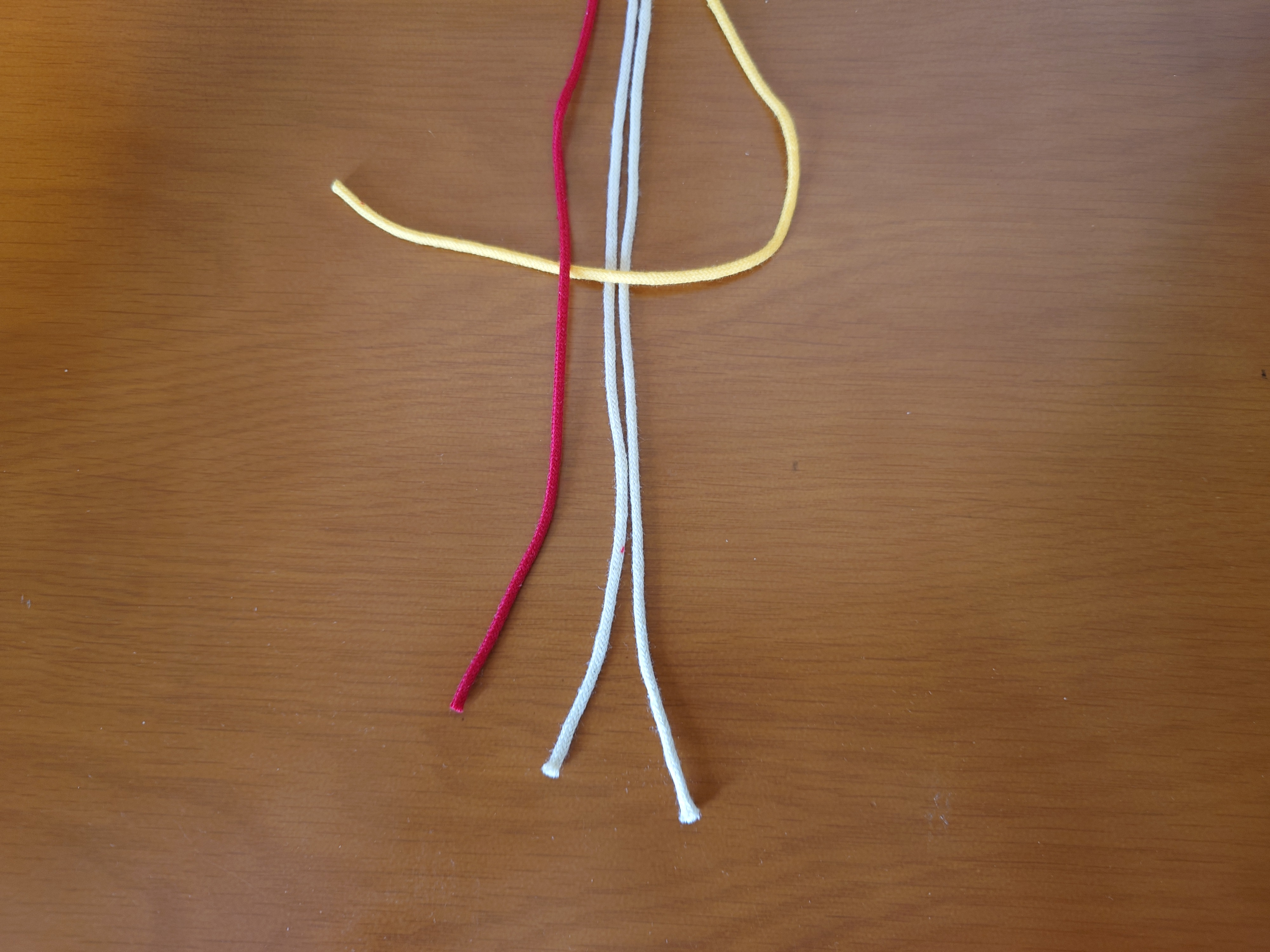 左端の紐をその上に置く