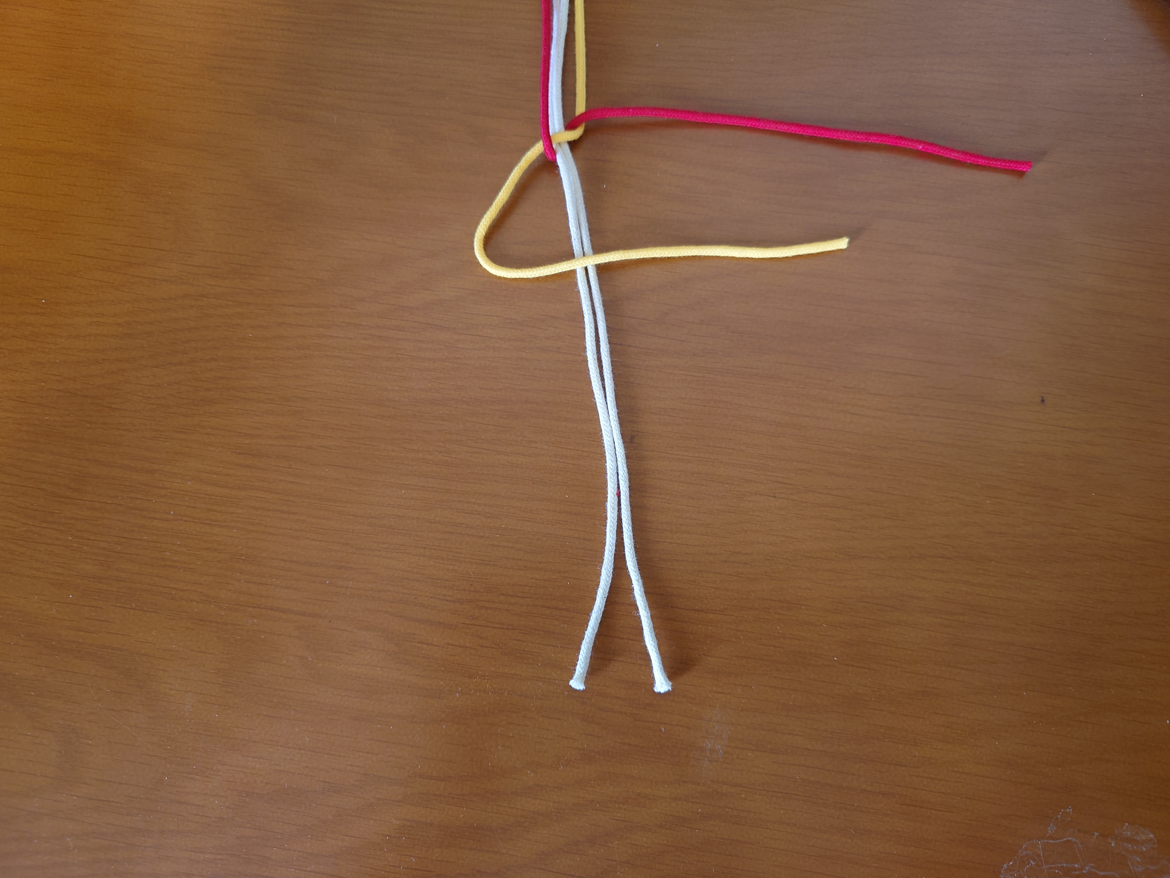 左端の紐を三角に置く